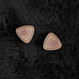 Jwanas Blush Pink Triangle Stud Earrings flat lay on dark background