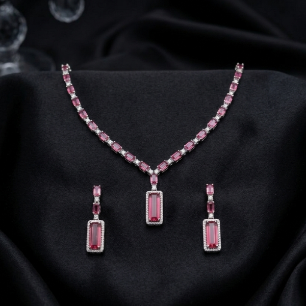 The Crimson Baguette Statement Set from Jwanas, necklace and earrings displayed on a black background
