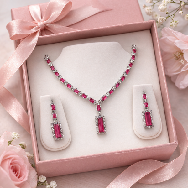 The Crimson Baguette Statement Set from Jwanas displayed inside an open pink jewellery box with roses and ribbon
