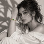 Black-and-white portrait of a model wearing the Jwanas Emerald-Green Heart Bangle Bracelet, with the bangle shown in colour