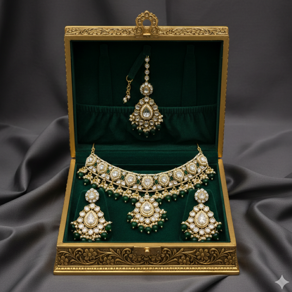 Jwanas Emerald-Green Rajwadi maang tikka and earrings displayed in jewellery box