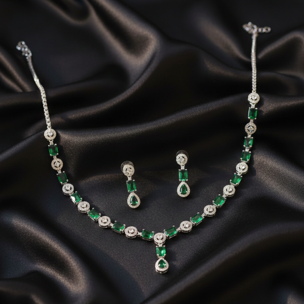 Emerald Queen necklace and drop earrings set on black fabric.