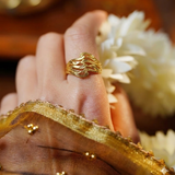 Close-up of a hand wearing the Jwanas Ethereal Wave Filigree Ring resting on a wooden surface