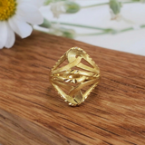 Jwanas Gilded Lattice Statement Ring displayed as a flat lay on a wooden surface with flowers