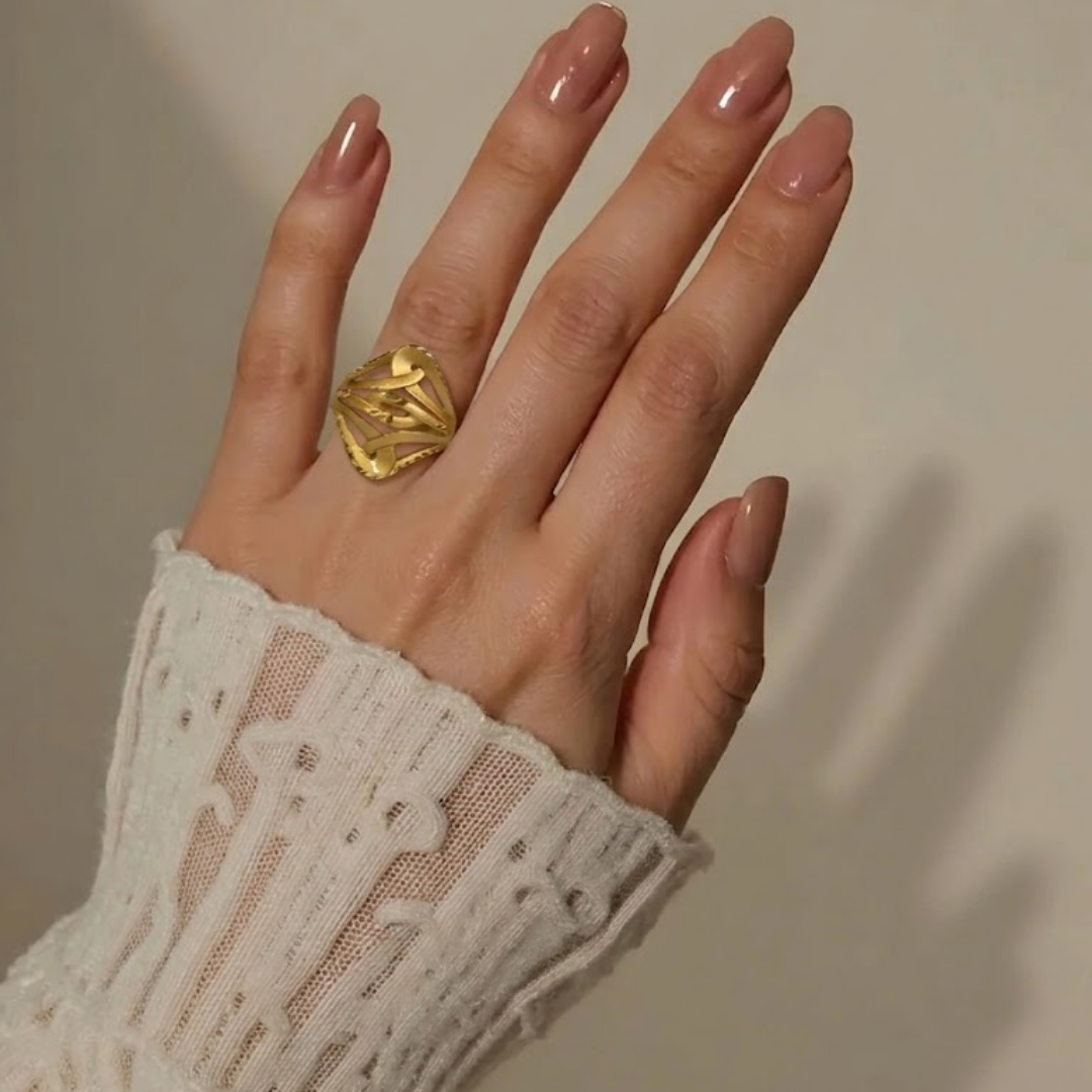 Close-up of a hand wearing the Jwanas Gilded Lattice Statement Ring, showing the lattice texture
