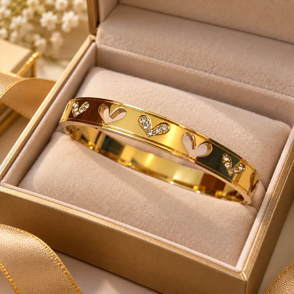 Jwanas Golden Heart Charm Bangle displayed in luxury gift box