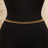 Jwanas Golden Pearl Elegance Waist Chain featuring a fine gold-tone chain and evenly spaced white pearl drops displayed on a black mannequin.