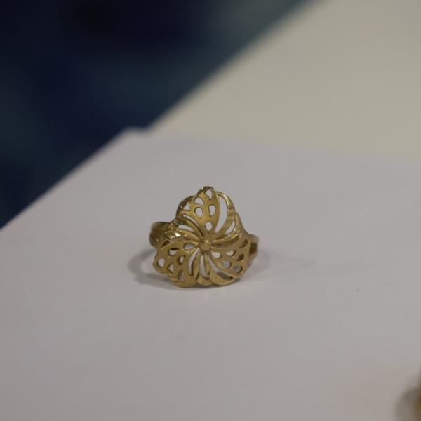Jwanas Golden Pinwheel Filigree Ring close-up on grey background