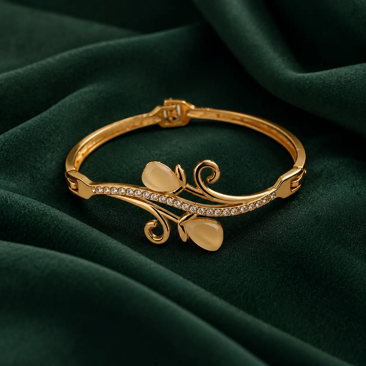 Jwanas Golden Vine Leaf Crystal Bangle on dark green velvet