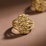 Jwanas Harvest Grain Textured Ring worn on pink background, close-up