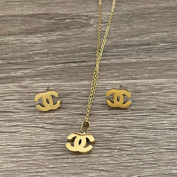 Jwanas Iconic Interlocking Pendant and Stud Set on wood-textured background