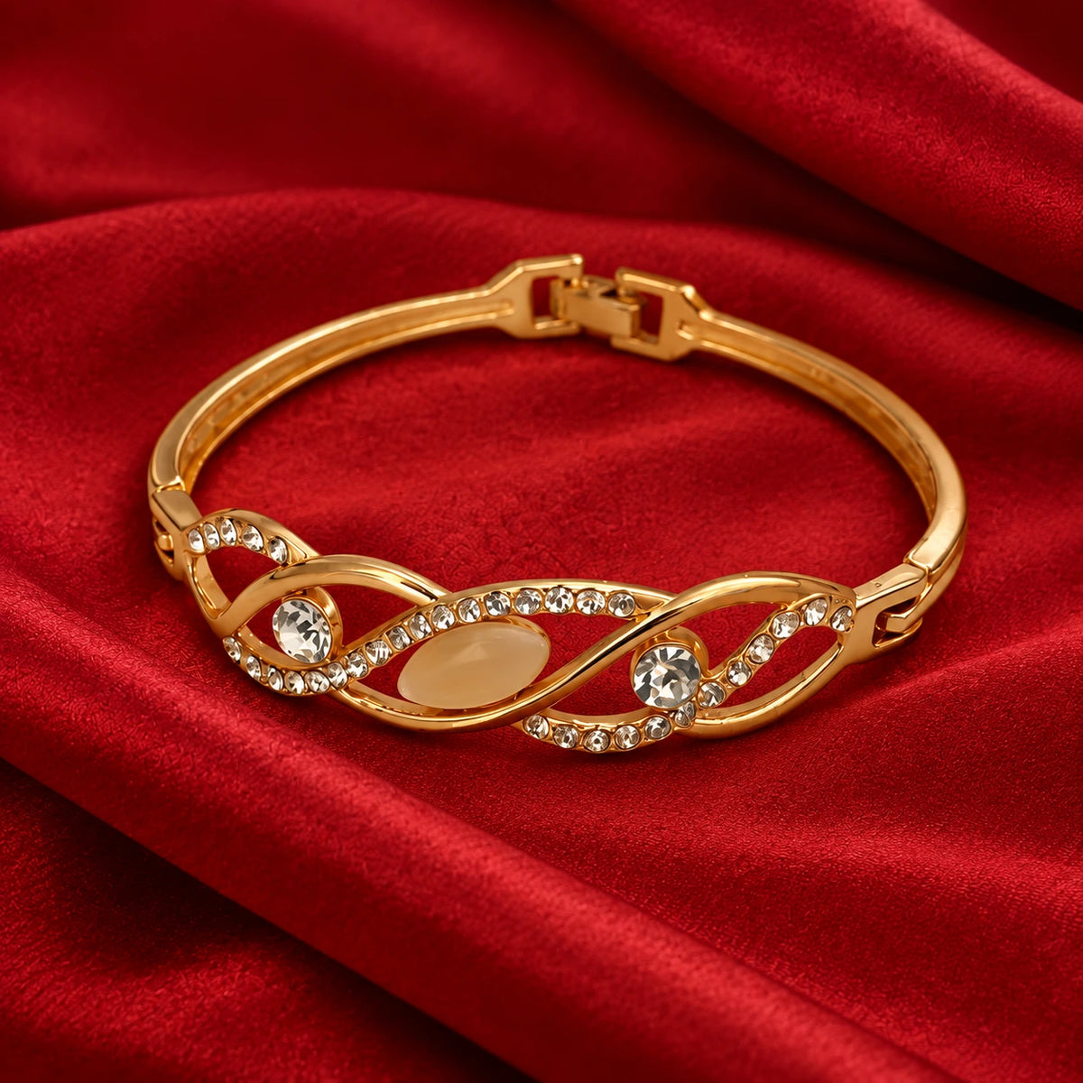 Jwanas Infinity Wave Crystal Bangle on red velvet fabric