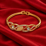 Jwanas Infinity Wave Crystal Bangle on red velvet fabric
