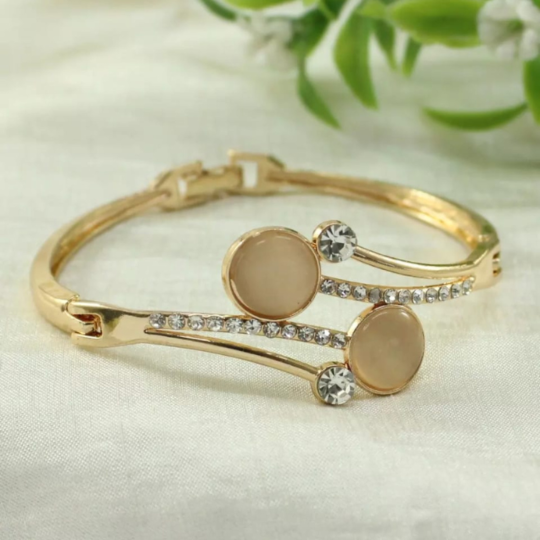 Jwanas Luna Celeste Bypass Bangle flat lay with greenery