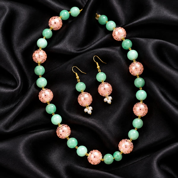Jwanas Meadow Jade & Blossom Beaded Necklace Set displayed as a flat lay on black satin fabric with matching earrings