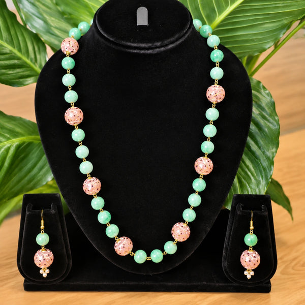 Jwanas Meadow Jade & Blossom Beaded Necklace Set displayed on a black bust stand with matching earrings