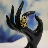 Jwanas Radiant Solar Mandala Ring shown on a hand against a dark textured backdrop