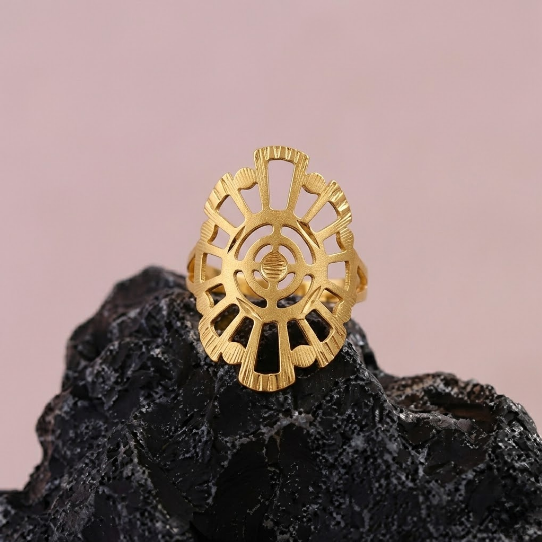 Jwanas Radiant Solar Mandala Ring displayed on a black rock against a pink backdrop