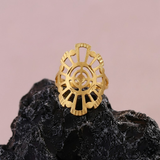 Jwanas Radiant Solar Mandala Ring displayed on a black rock against a pink backdrop