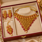 Jwanas Rani Ruby-Toned Bridal Choker Set displayed inside an open maroon jewellery box with earrings and Maang Tikka