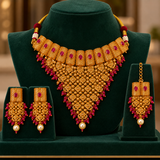 Jwanas Rani Ruby-Toned Bridal Choker Set displayed on a green velvet bust with matching earrings and Maang Tikka