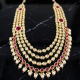 Jwanas Ruby-Toned Layered Kundan Mala necklace displayed as a flat lay on a dark surface