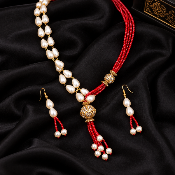 Jwanas Scarlet Pearl Cascade Necklace Set displayed as a flat lay on black satin fabric with matching earrings
