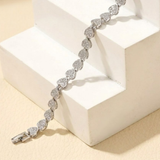 Jwanas Silver Heart-Link Crystal Bracelet flat lay on wooden blocks