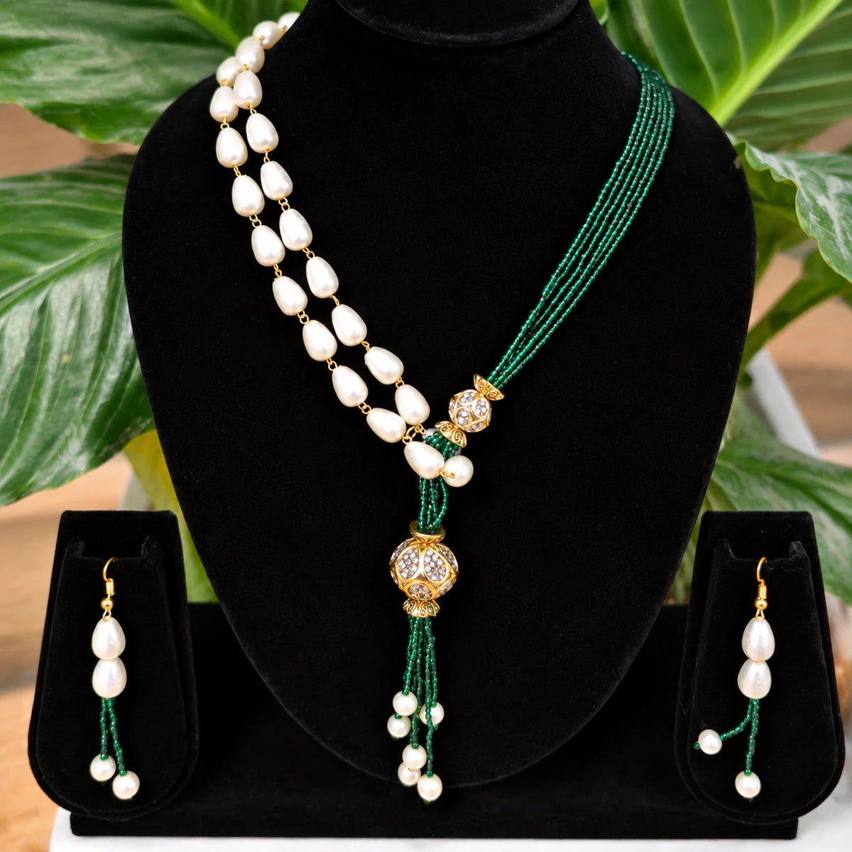 Jwanas Verdant Pearl Cascade Necklace Set displayed on a black bust stand with matching earrings