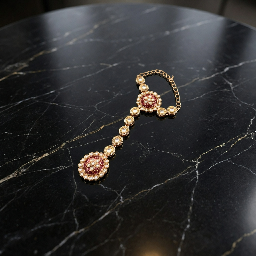 Jwanas Haathphool (hand harness) from the Zeenat Ruby-Toned Bridal Choker Set on a black marble surface