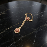 Jwanas Haathphool (hand harness) from the Zeenat Ruby-Toned Bridal Choker Set on a black marble surface